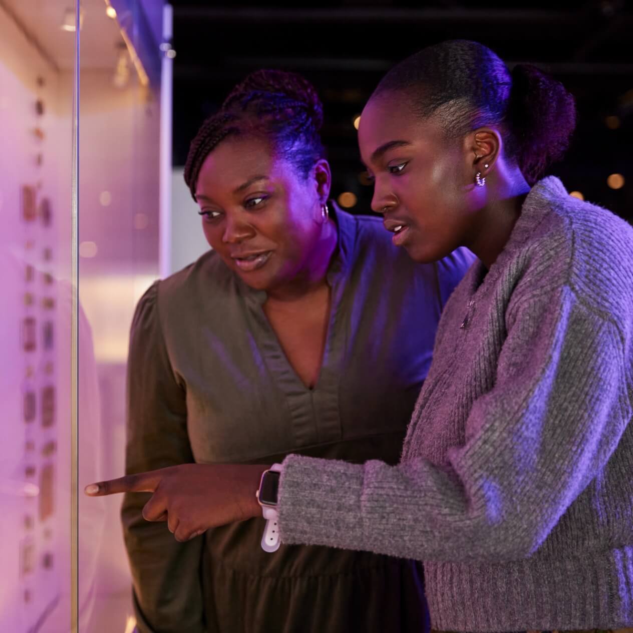 Two people looking at artifacts in a museum with wonder.