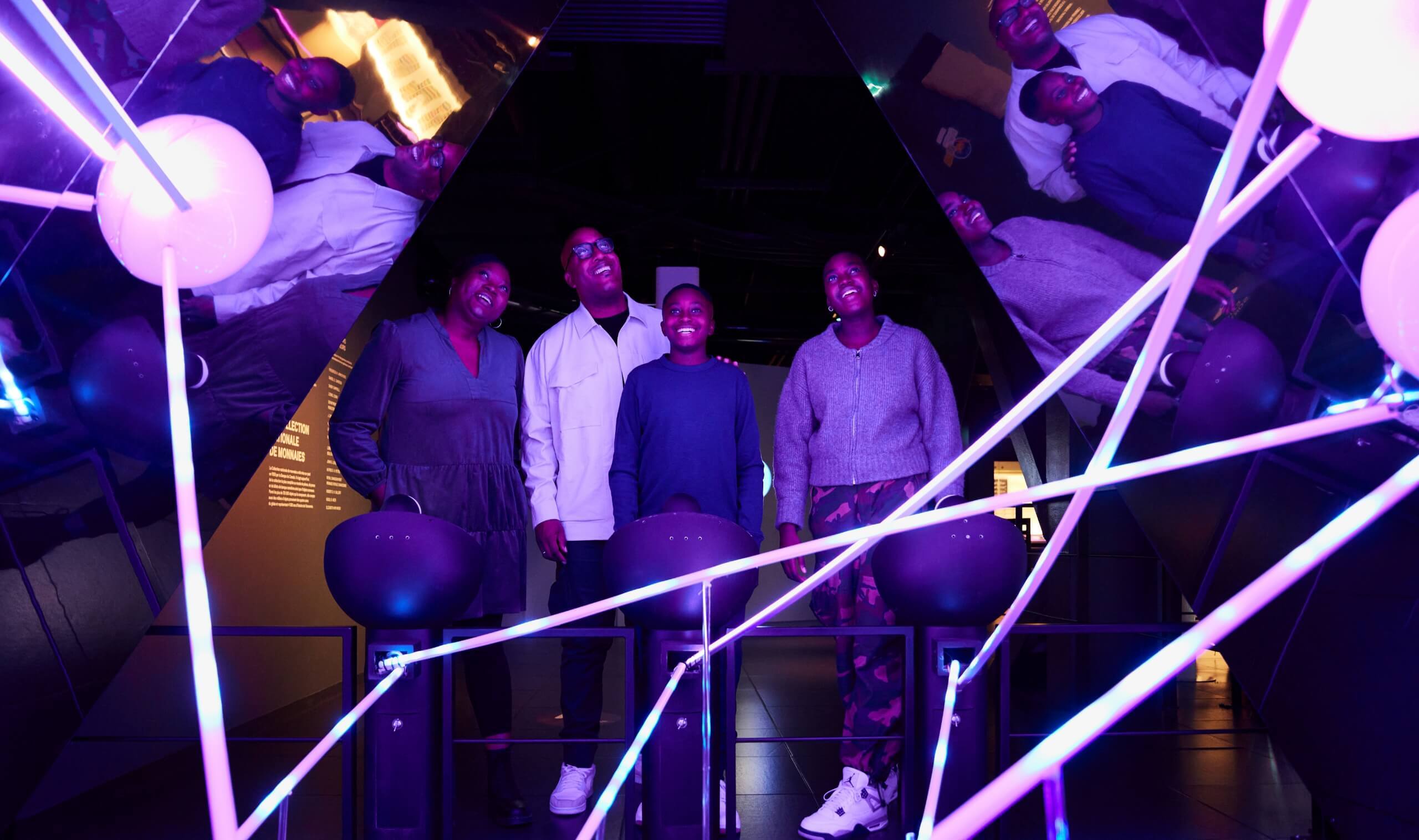 Museum patrons are having fun and laughing in a crazy mirror room.